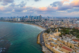 Coastline with a modern city skyline and old port town from above