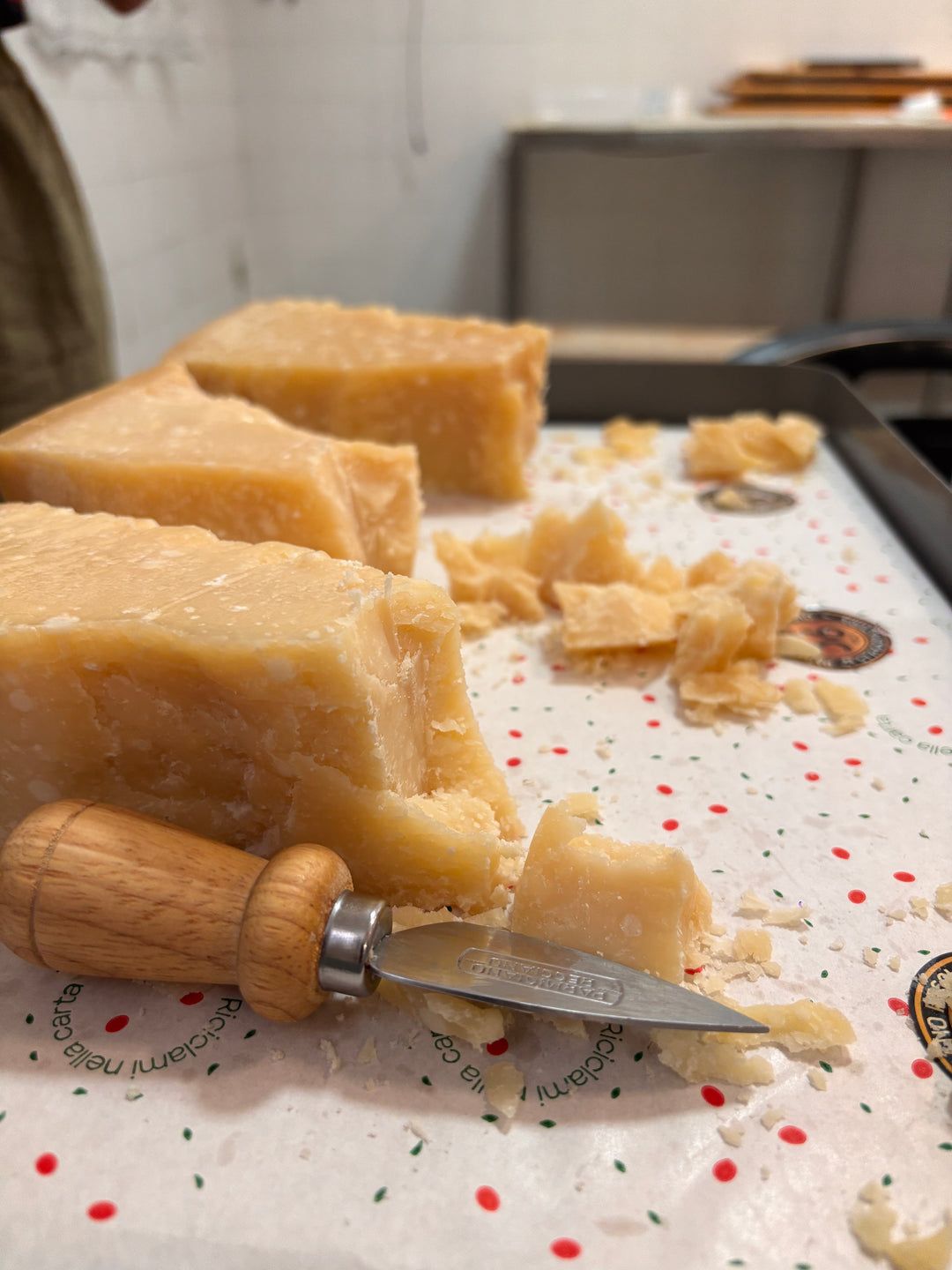Chunks of aged hard cheese with a small cheese knife