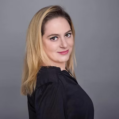 Portrait of a smiling woman with long blonde hair in a black top