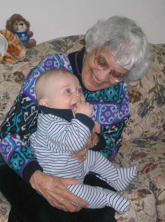 Grandmother smiling as she holds a baby on her lap