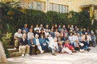 Large group of older travellers posing for a photo outside a building