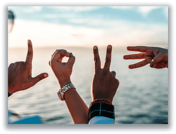 Hands spelling LOVE against a sea backdrop