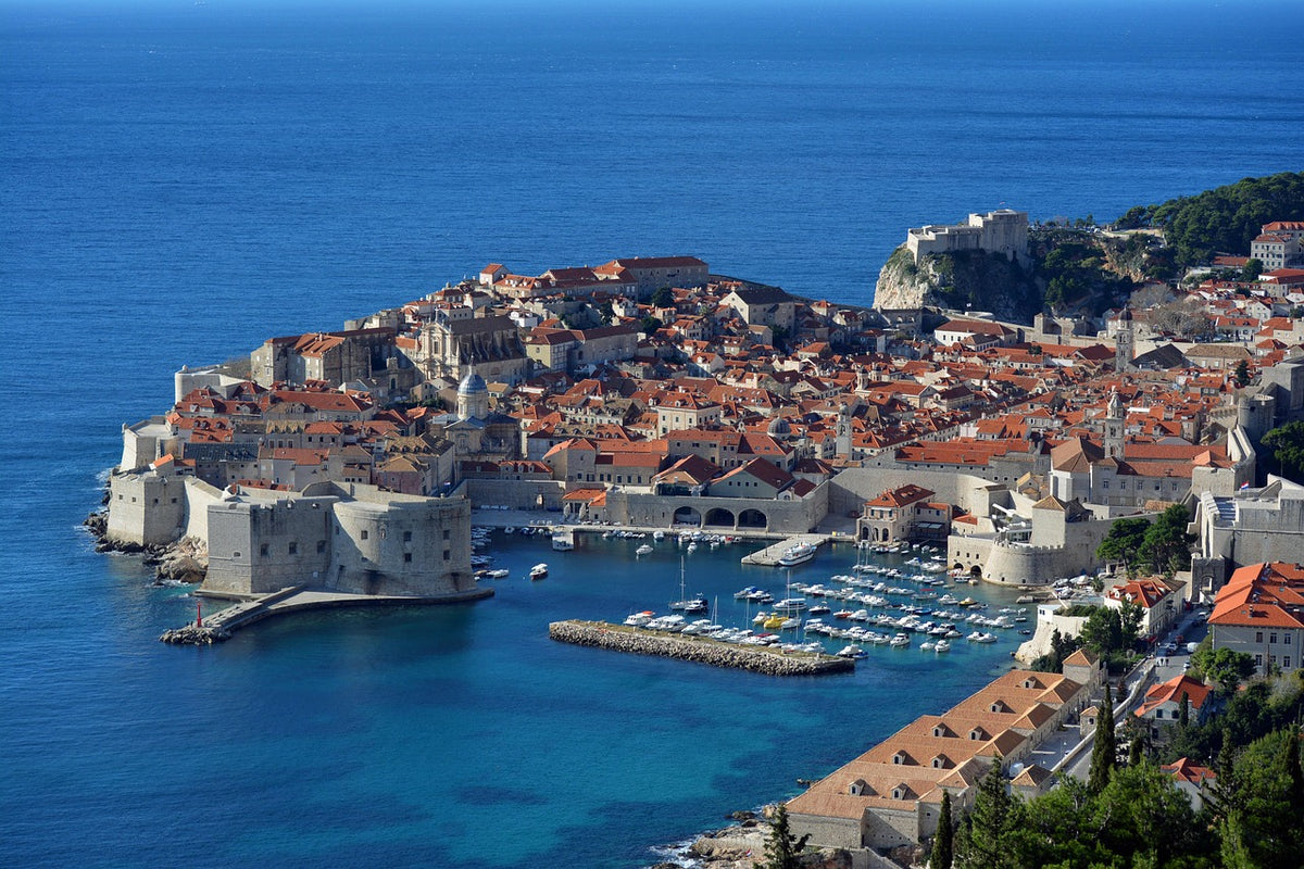 Walled old town with red roofs on a peninsula in a deep blue sea