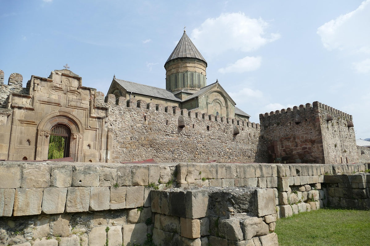 Medieval stone fortress walls surrounding a domed stone church