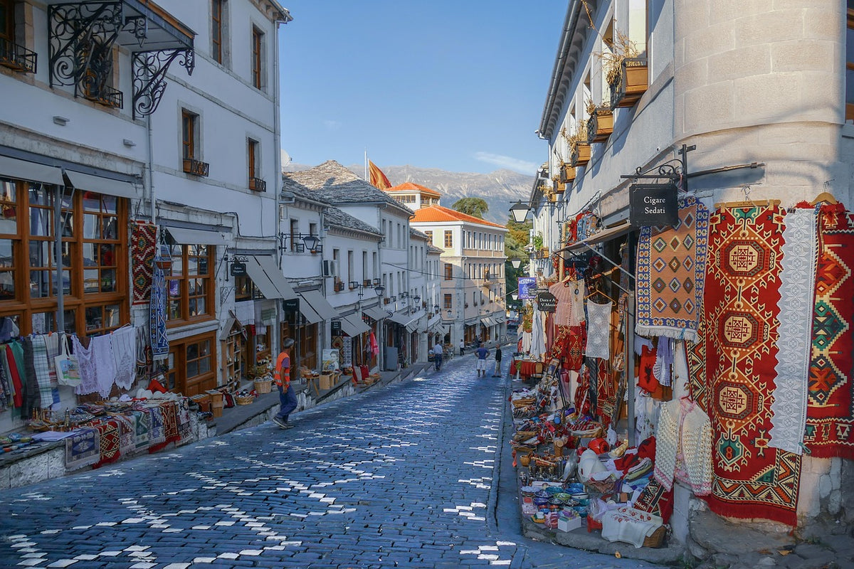 Cobbled old town street lined with shops selling rugs and textiles