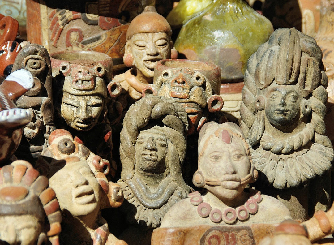 Clay figurines and carved masks at a craft market