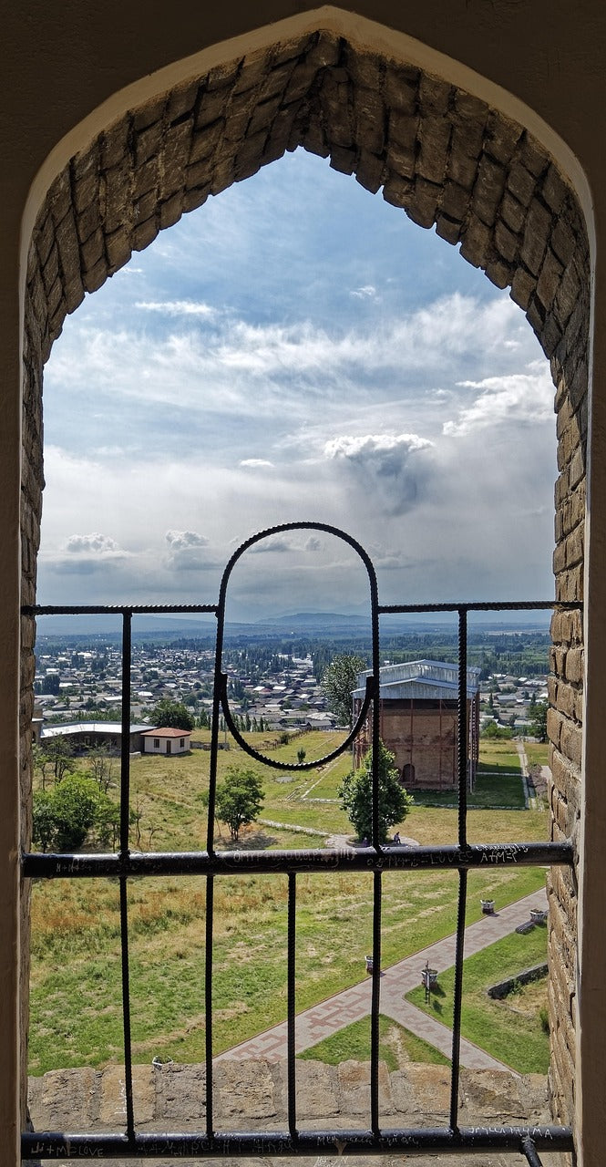 Pointed stone archway framing a view over a town