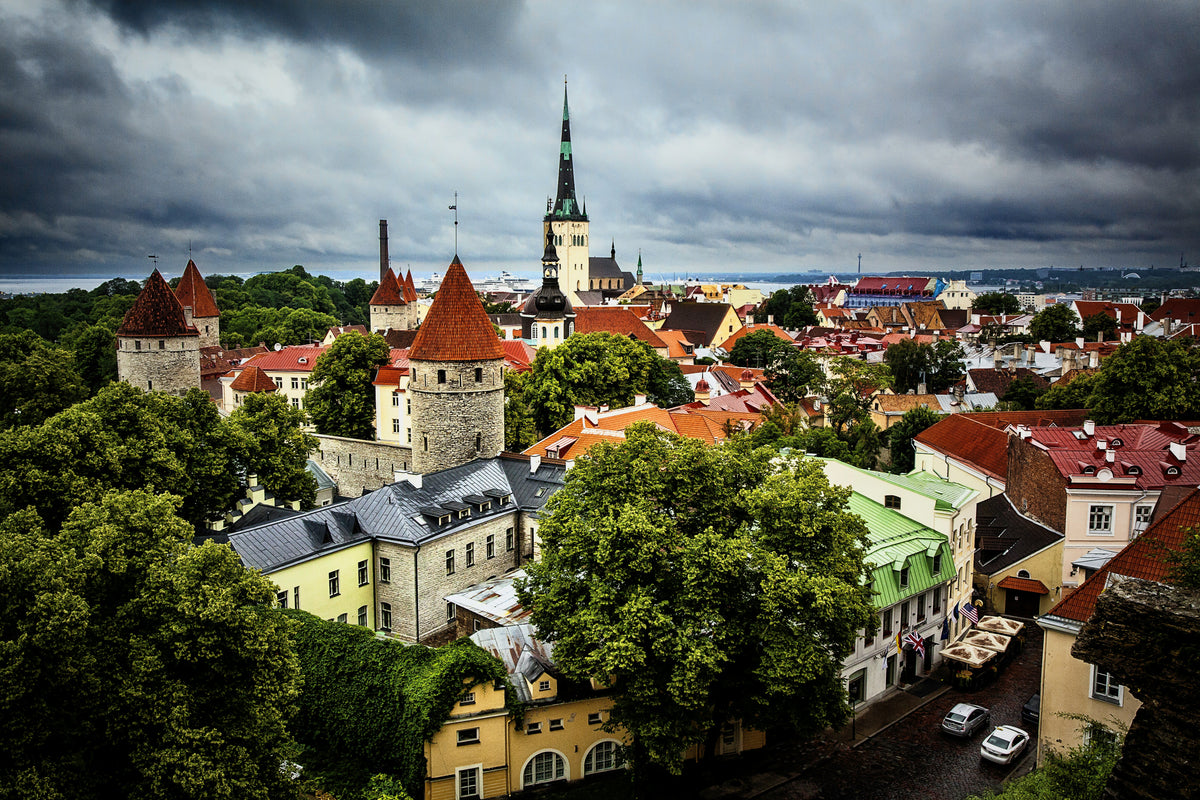 Red rooftops and church spires of Tallinn Old Town under a stormy sky