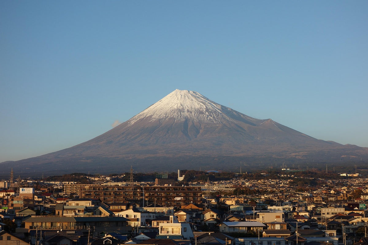 Mount Fuji snow-capped above a sprawling town