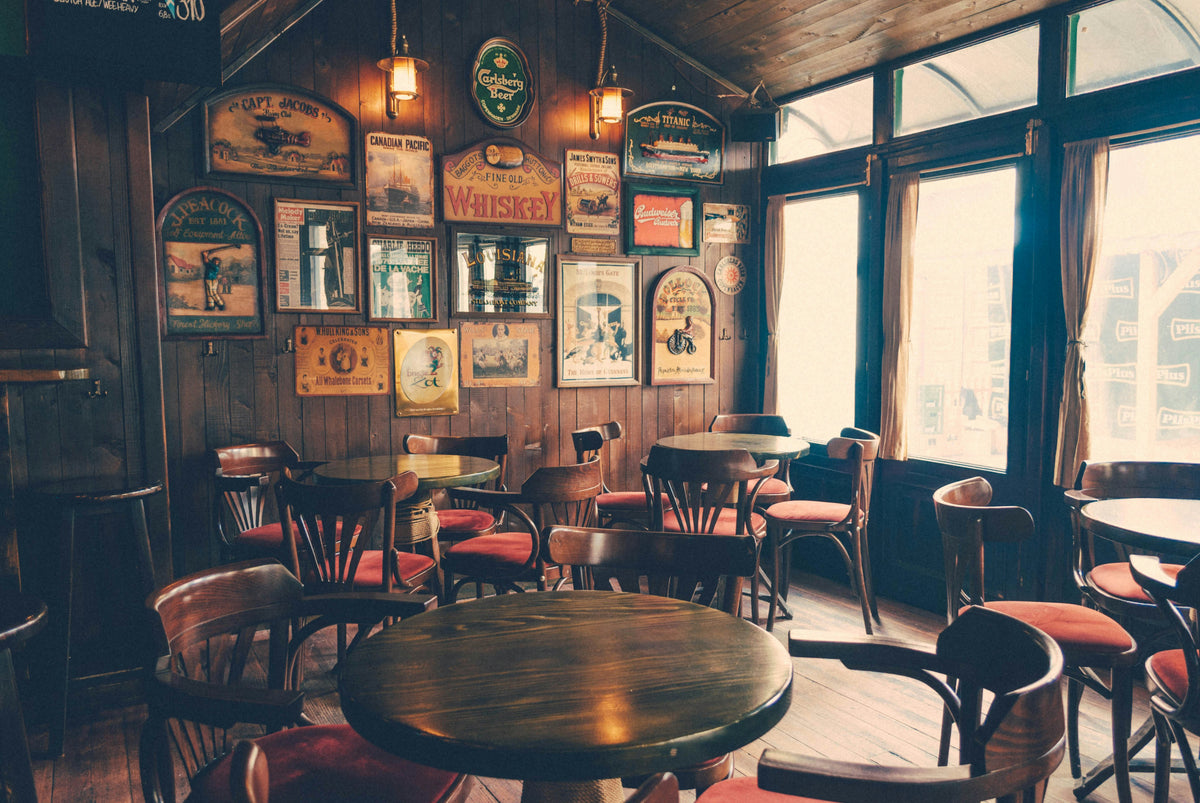 Cozy wood-panelled pub interior with round tables and framed pictures