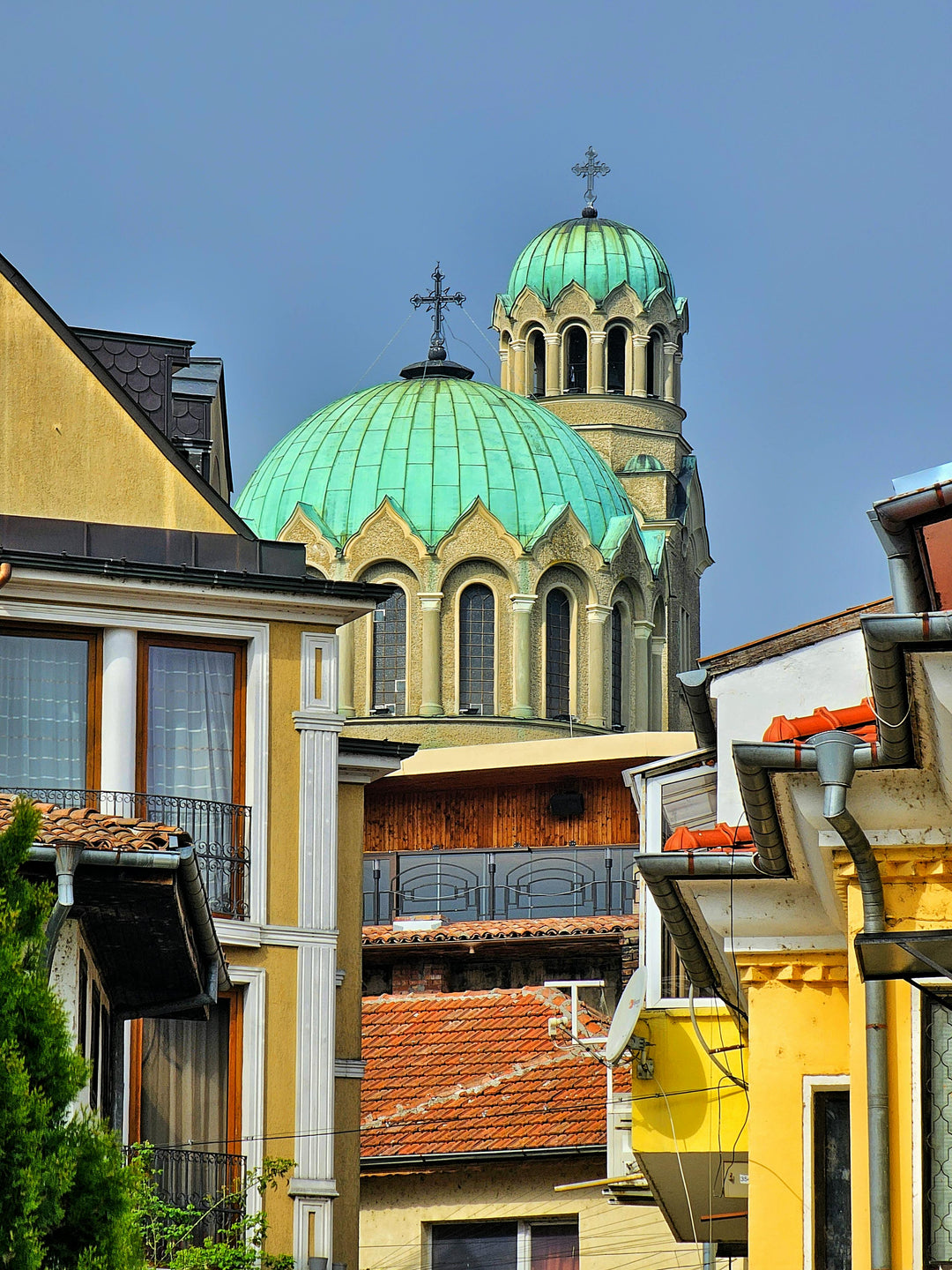 Green-domed Orthodox church behind colourful old houses