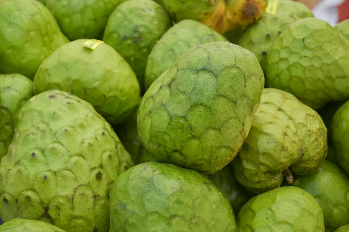 Pile of green custard apples at a market