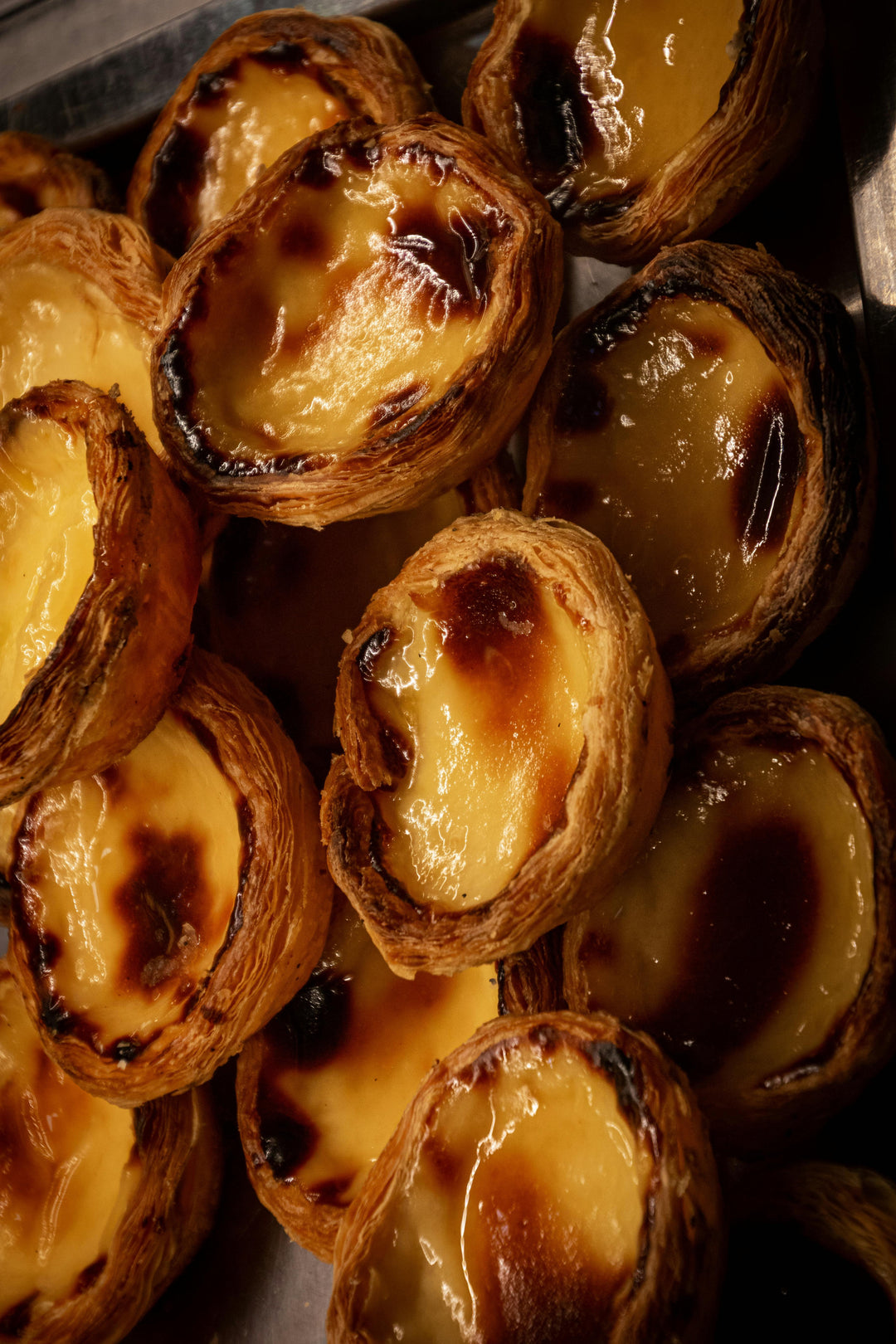 Close-up of golden caramelised custard tarts
