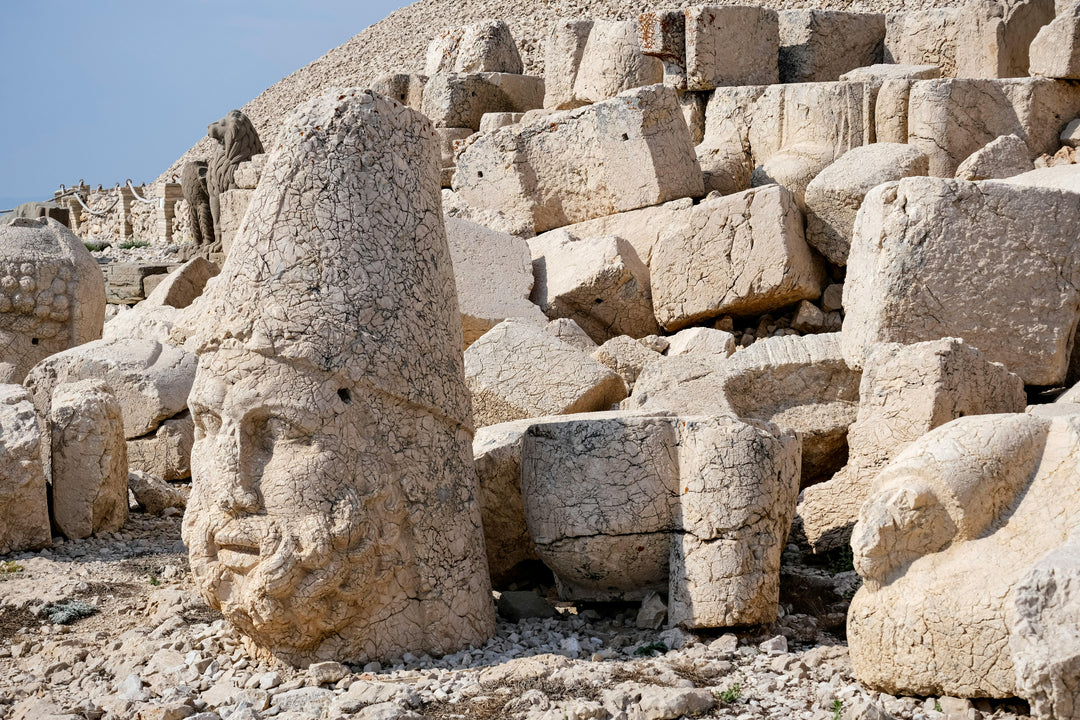 Giant carved stone heads among tumbled blocks on a mountaintop
