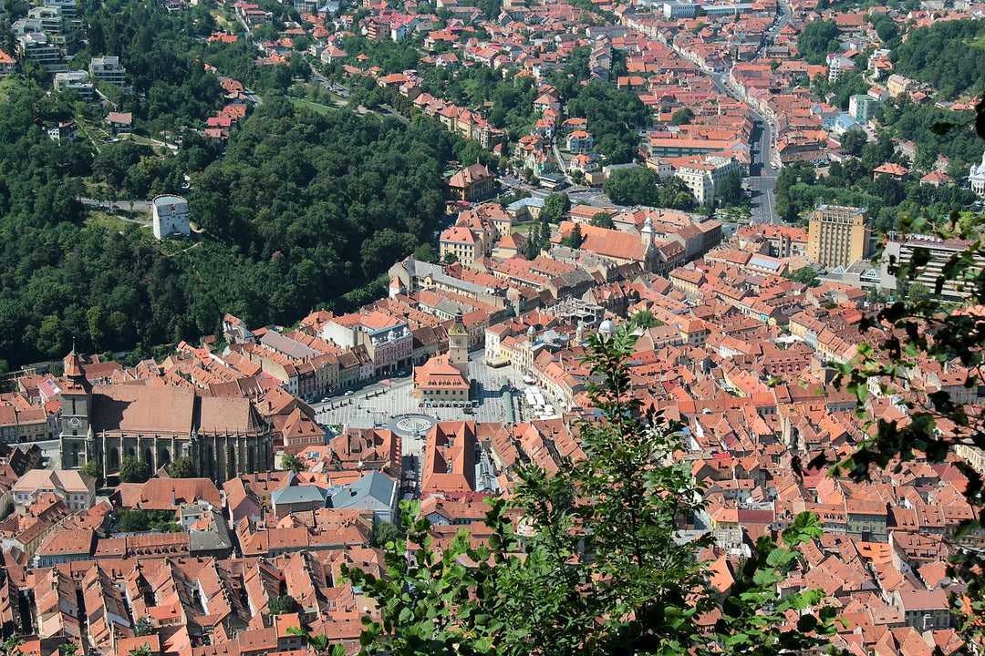 Aerial view of a red-roofed old town surrounded by green hills