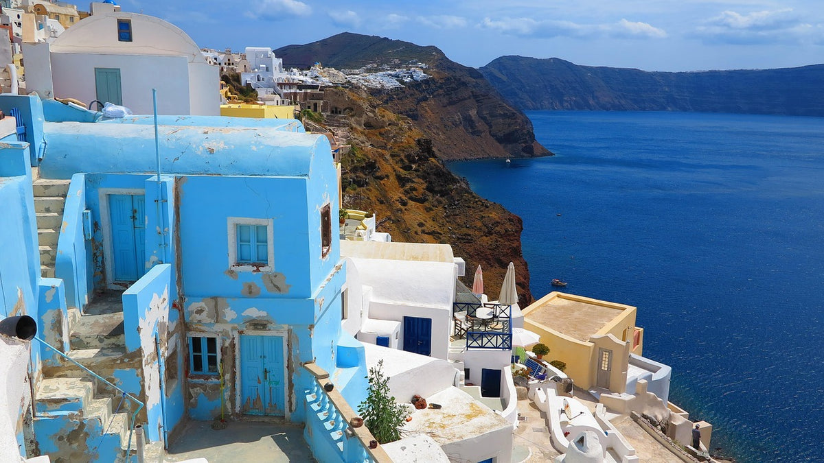Blue and white cliffside houses overlooking a deep blue sea