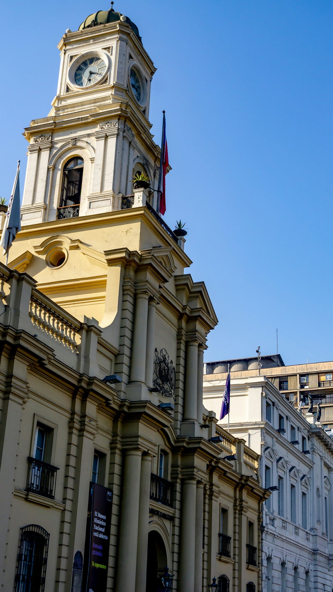 Colonial yellow building with a clock tower against blue sky