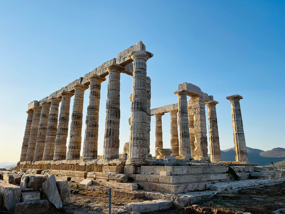 Ruined Greek temple columns on a clifftop above the sea