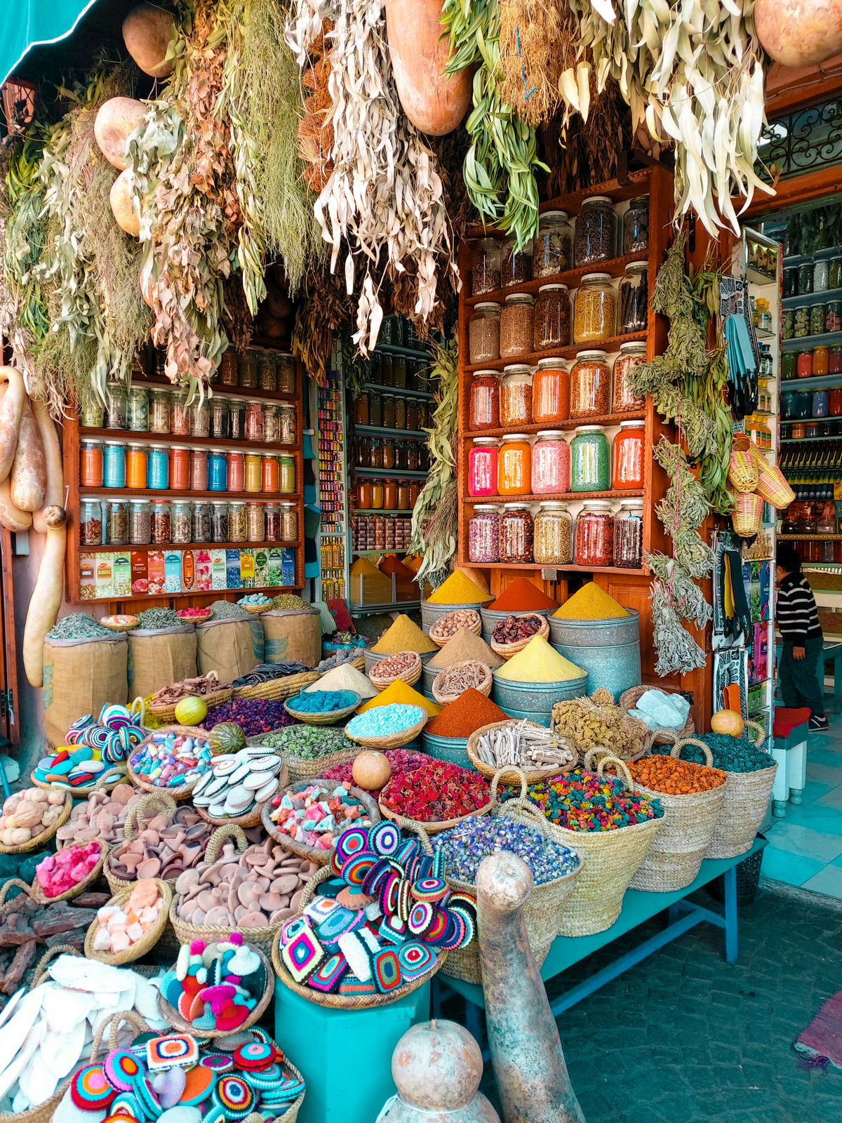 Market stall piled with spices, jars, dried herbs and colourful goods